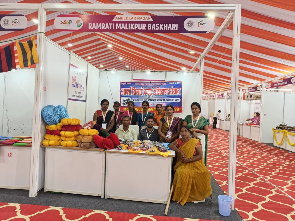 Women Displaying Finished Garments Made During Workshop